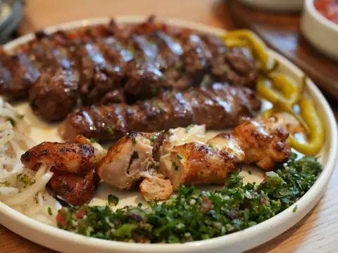 Kofta and grilled chicken on a bed of onions and herbs
