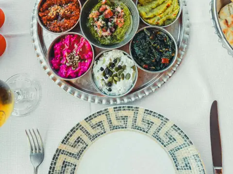 A round tray of colourful mezze dips